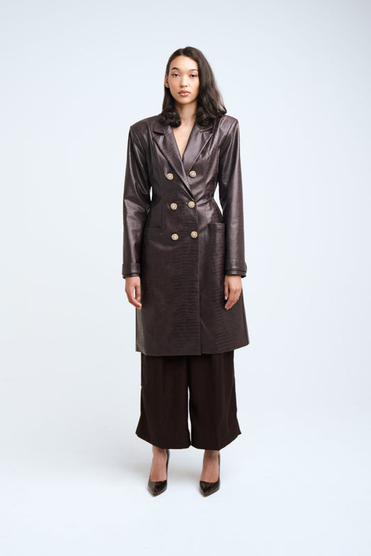 Woman wearing a brown coat and pants on a white background